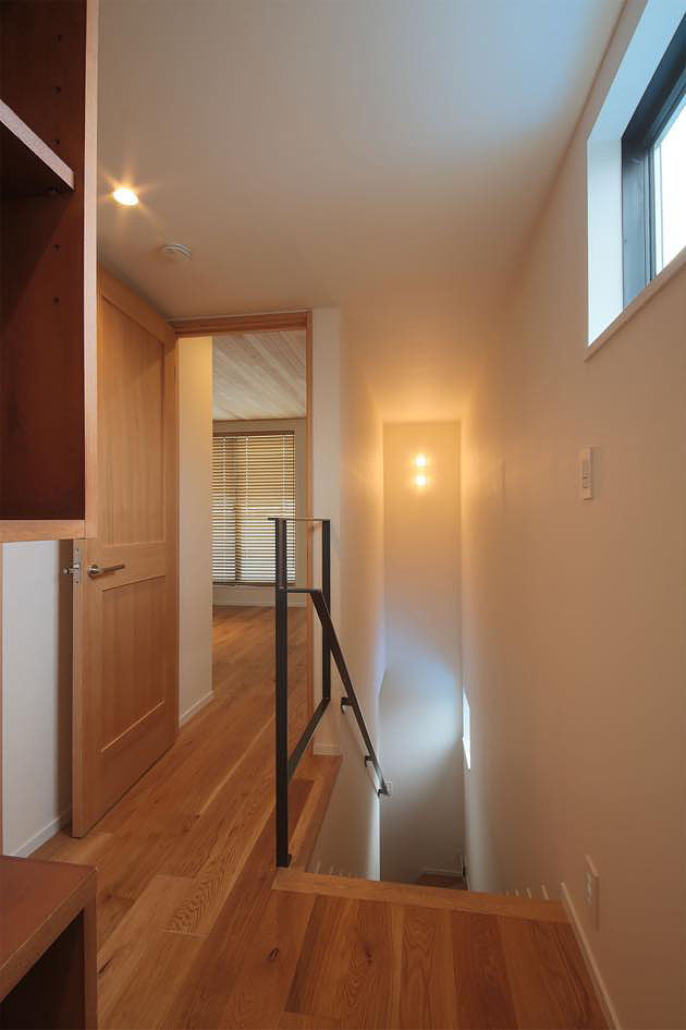 2階廊下・階段ホール,個性的なフローリング・無垢の木製ドア・天井のウッドパネル貼り・木ルーバーにより雰囲気のある空間