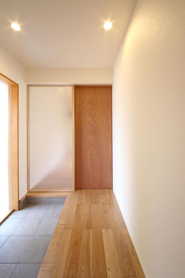 玄関とリビングを仕切る素材感の有る引戸,シンプルナチュラル