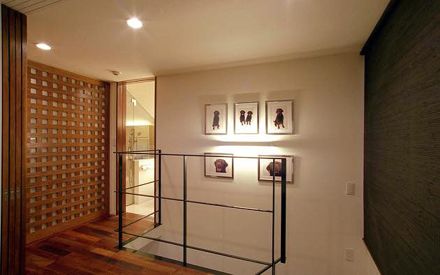 モダンデザインの住宅,寝室と格子戸で仕切られた階段ホール,間接照明で演出された階段ホール